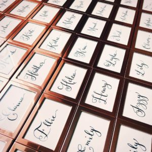 Wedding calligraphy place settings or place names also double up as favours for guests in rose gold frames