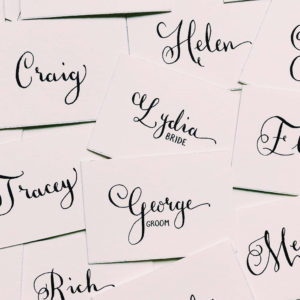 Close up place setting calligraphy and favour for bride and groom