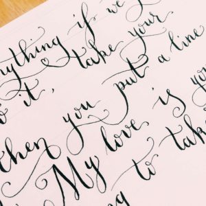 Close up of flourished calligraphy for first dance lyrics or custom vows
